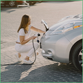 Focus Coface : Le boom des métaux liés aux véhicules électriques est-il durable ? La photo montre une femme qui branche une voiture électrique à une source d'énergie.